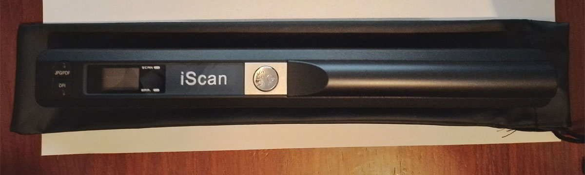Стр.02 Портативный ручной сканер PhotoScan лежит на чехле для ношения и хранения девайса.